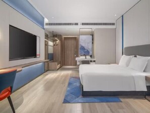 A modern hotel room with a large bed, a flat-screen TV, a desk, and a bathroom with a mirror. - Holiday Inn Express Nanchang High-tech Zone (Nanchang)