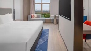 A modern hotel room with a large bed, a seating area with a view, and a flat-screen TV. - Holiday Inn Express Nanchang High-tech Zone (Nanchang)