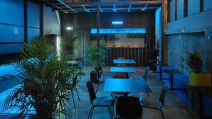 En modern inredning med ett restaurangområde, sittplatser och en väl synlig skylt med texten ”JOY BOGOTA”.