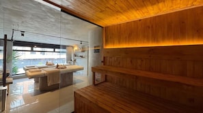 A spa room with a massage table, wooden paneling, and a glass partition. - Hostel Joy Cll 85 (Bogotá)