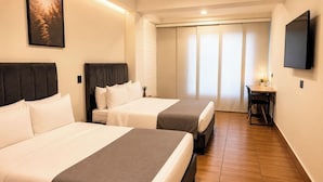 A hotel room with two beds, a desk, a TV, and a sliding door closet. - Inactivo Hotel Natura Express (Medellín)