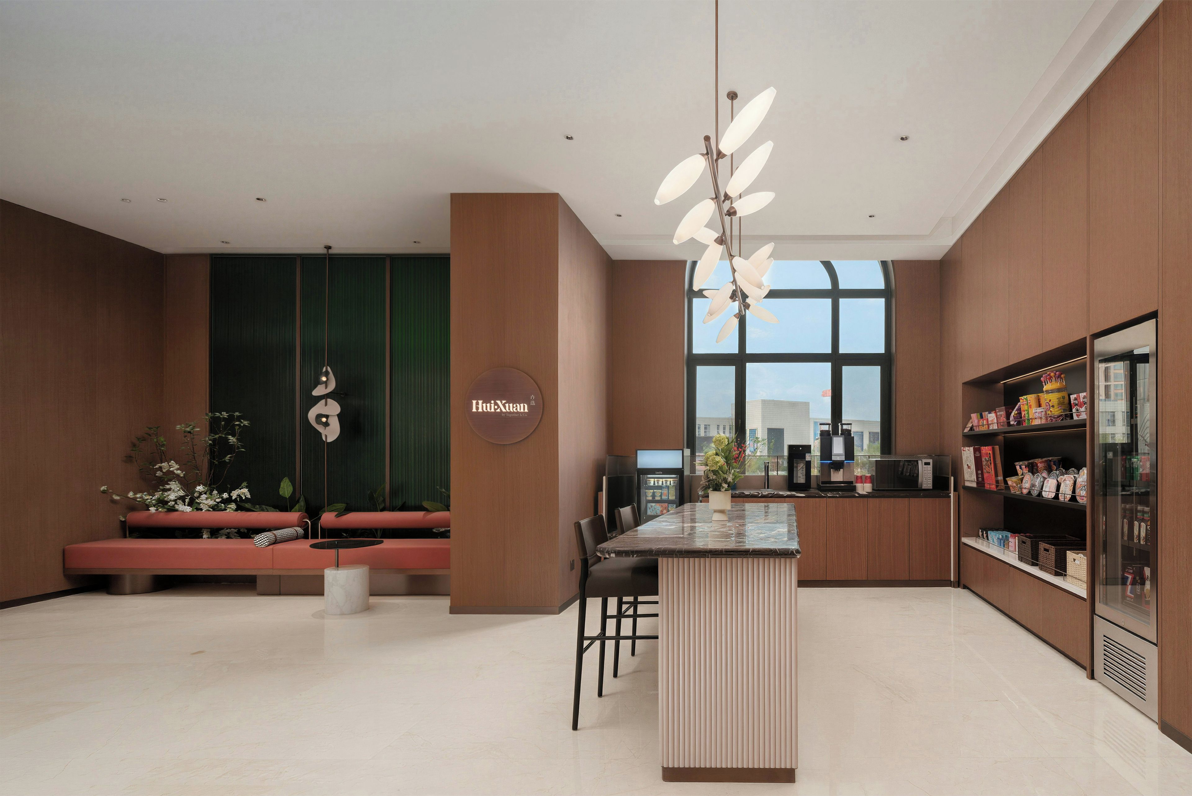 A modern kitchen with a central island, seating area, and a large window providing natural light.