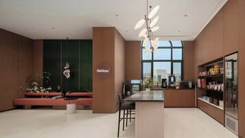 A modern kitchen with a central island, seating area, and a large window providing natural light.