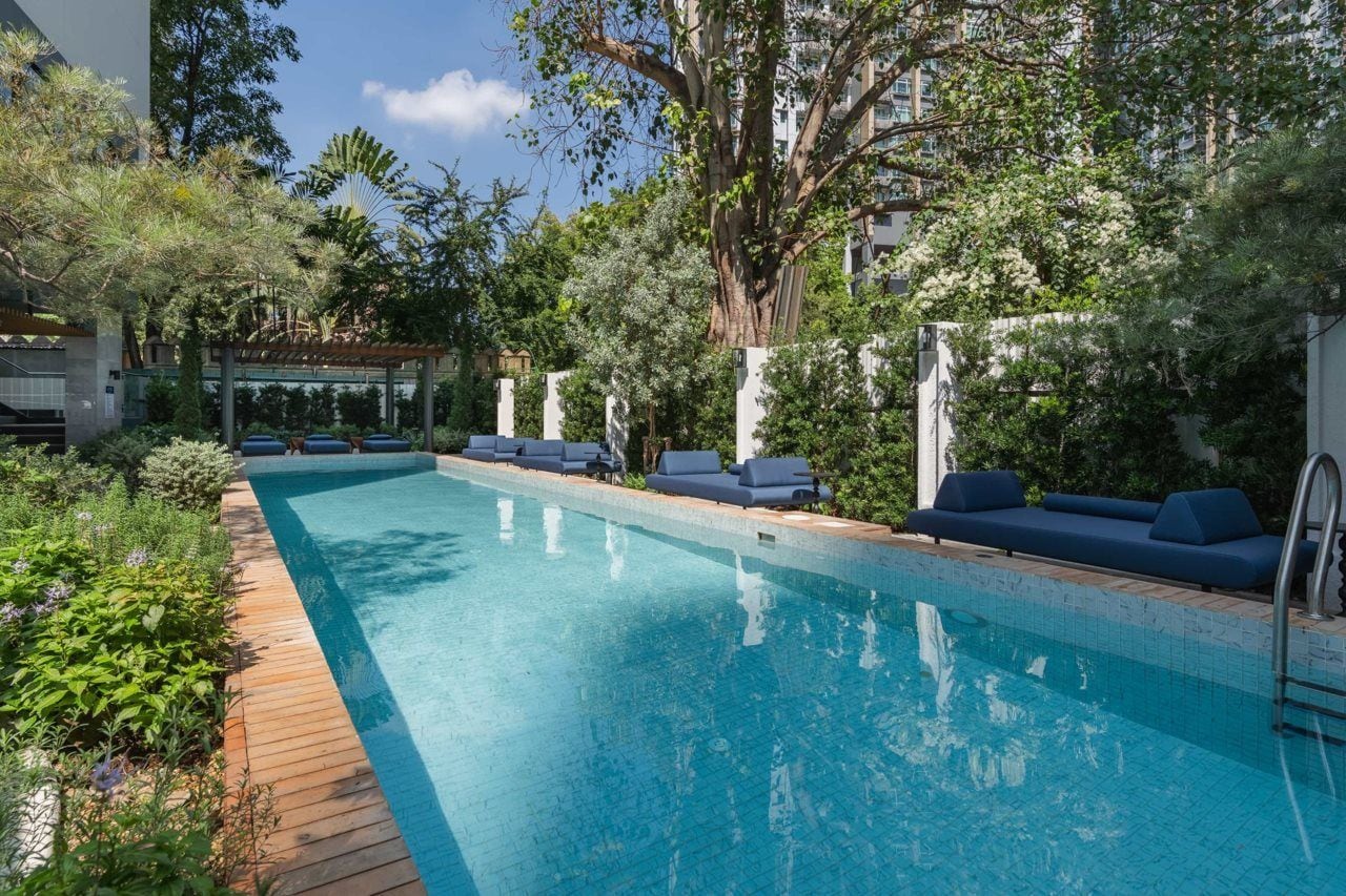 A swimming pool with lounge chairs and a wooden deck.