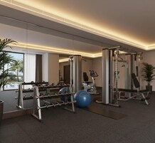 Un gimnasio moderno con equipo de ejercicio, un espejo grande y vistas al exterior.
