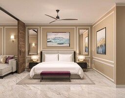 Una habitación de hotel con una cama grande, un ventilador de techo, un sofá y obras de arte en las paredes.