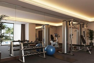 Un gimnasio moderno con equipamiento de ejercicio, una máquina de remo y una bicicleta estática.