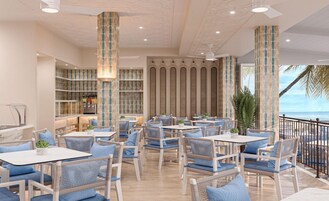 Un restaurante con terraza, vistas al océano y una decoración interior moderna.