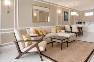 Una sala de estar moderna con un sofá, un sillón, una mesa de centro y un comedor.