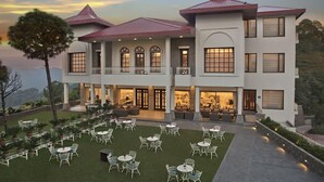 A multi-story hotel with a courtyard, outdoor seating, and a view of the surrounding landscape. - Fortune Select Forest Hill Kasauli (Solan)
