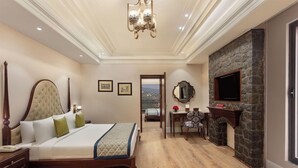 A spacious bedroom with a large bed, a stone fireplace, and a view through an open door. - Fortune Select Forest Hill Kasauli (Solan)