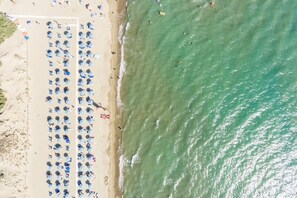 A beach with rows of umbrellas and sun loungers.