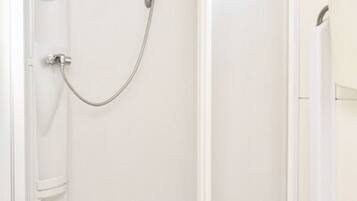 A white bathroom with a shower enclosure and a door.