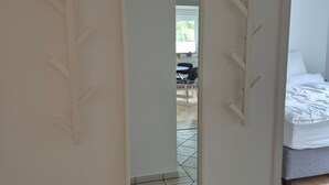 Een hotelkamer met een bed, een spiegel en een betegelde vloer.