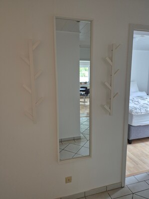 Ein Hotelzimmer mit einem Bett, einem Spiegel und einem Fliesenboden.