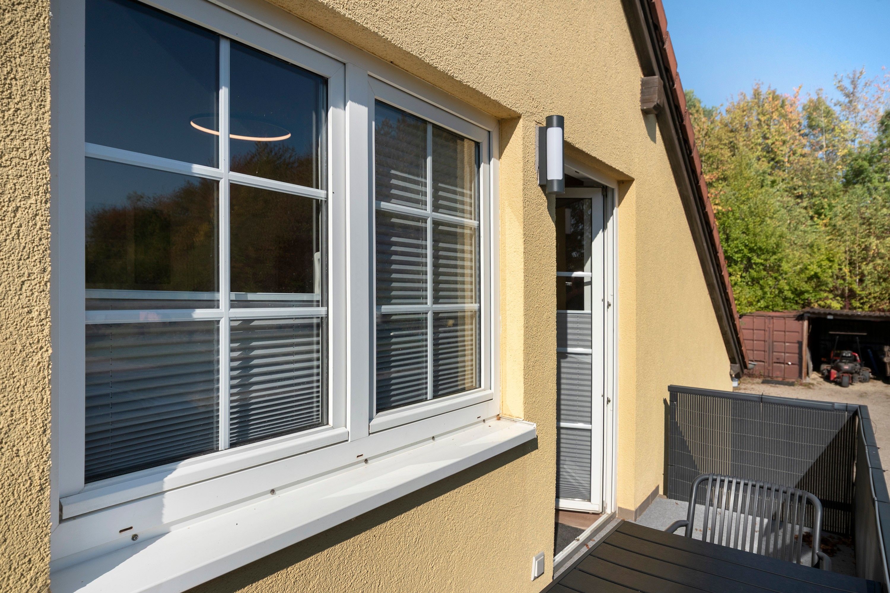 A building with a large window and a door with a small porch area.