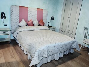 A bedroom with a bed, bedside tables, a wardrobe, and a chair. - Rhona's Rooms B&B (Rome)