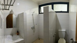 Ein Badezimmer mit Waschbecken, Spiegel, Dusche und Toilette.