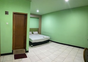 Una habitación con cama, puerta y suelo de baldosas.
