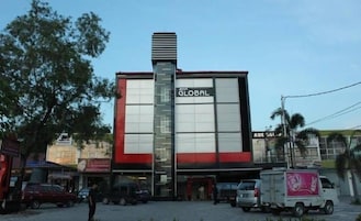 Un edificio con un llamativo letrero 'GLOBAL', una estructura vertical grande y un frente de color rojo y blanco.