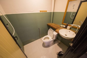 Ein kleines Badezimmer mit Toilette, Waschbecken und Spiegel.