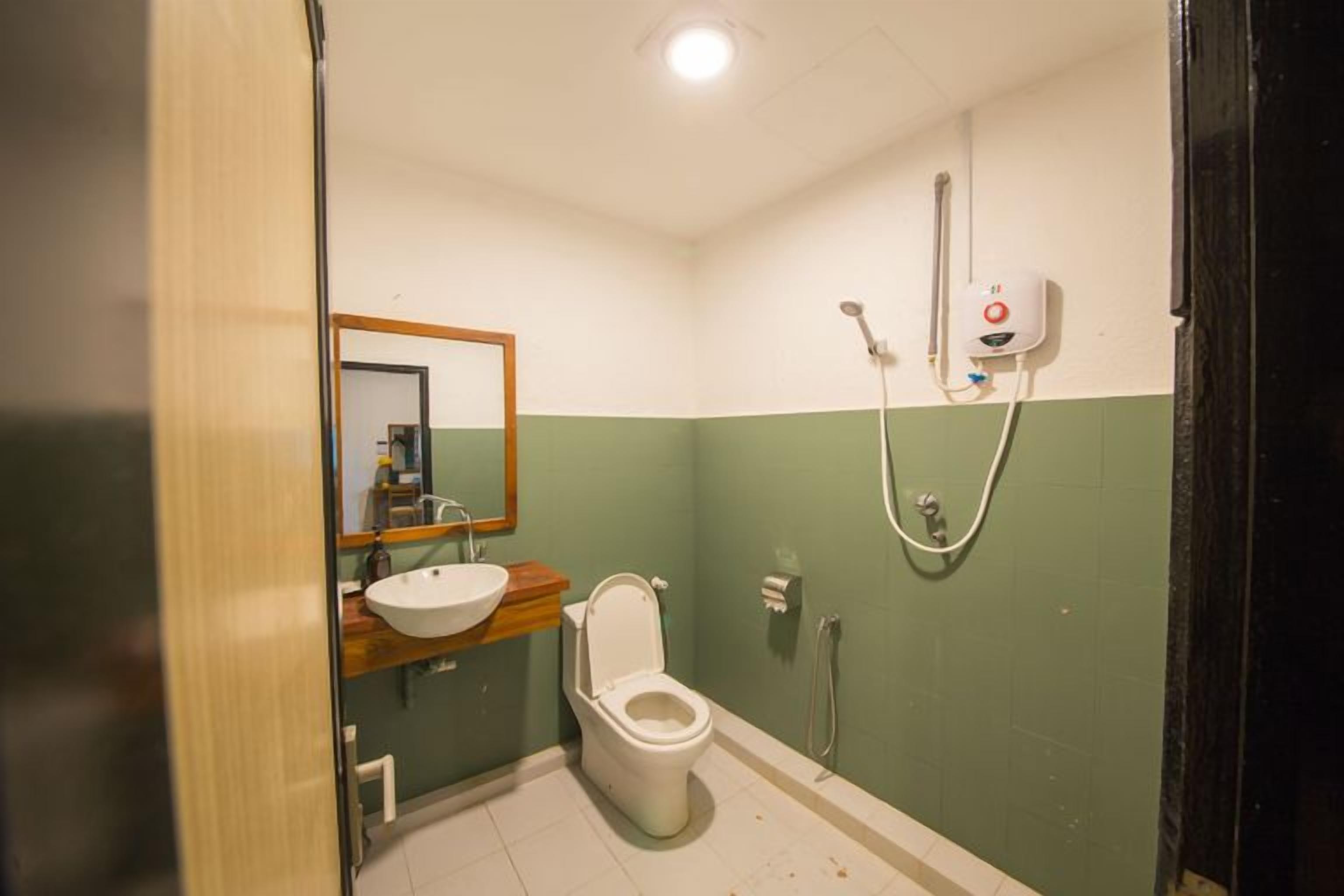 A bathroom with a toilet, sink, and shower.