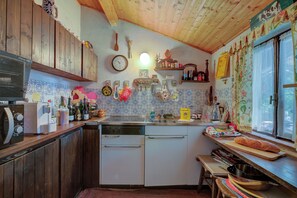 Una cocina con armarios de madera, un reloj y diversos utensilios de cocina.