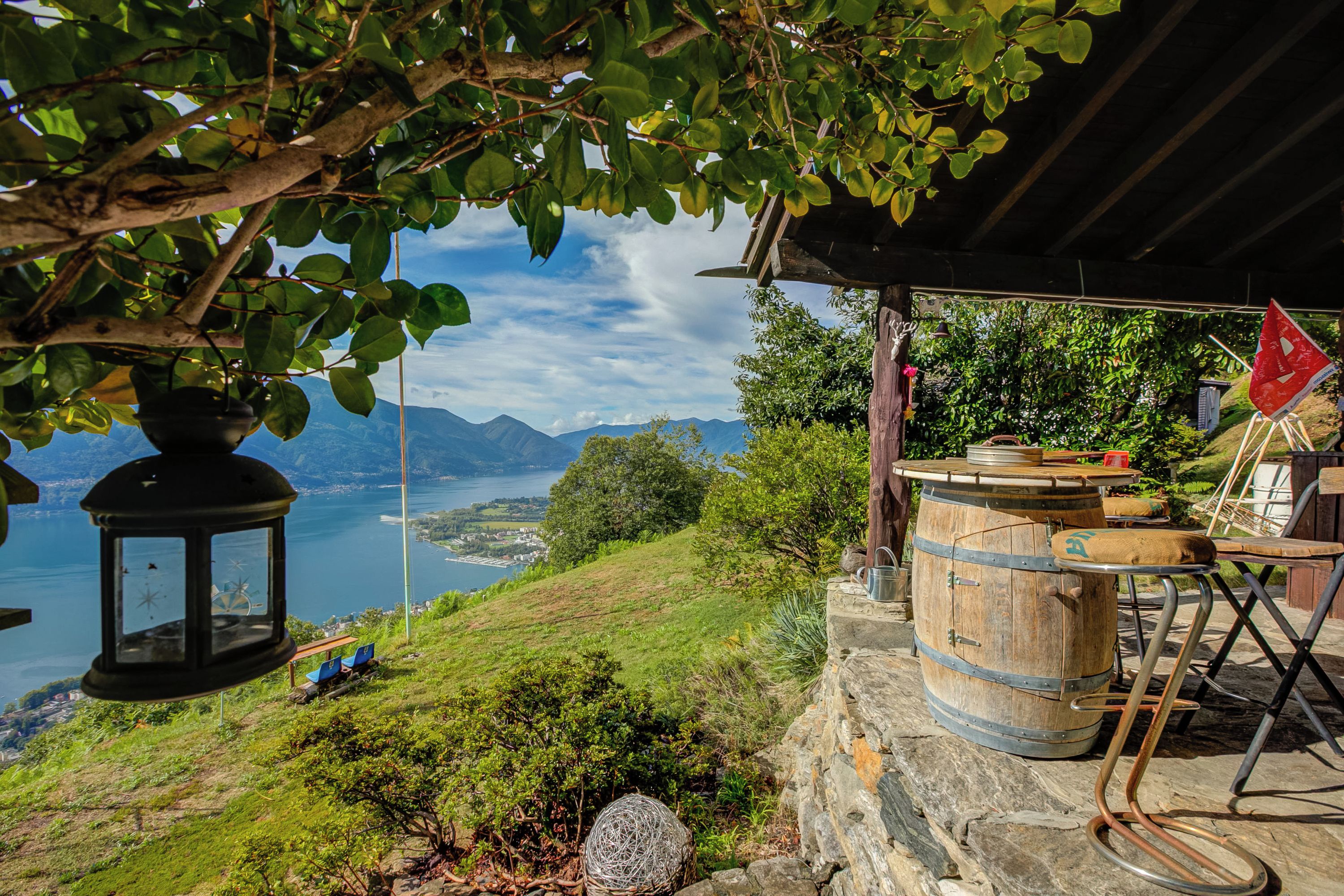 Ein rustikaler Sitzbereich im Freien mit Blick auf einen See und Berge.