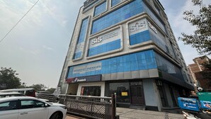 Een meerhoog bedrijfsgebouw met borden waarop 'SIS Group Enterprises' en 'Rajasthan Rajya Vidyut Utpadan Nigam Limited' staan.