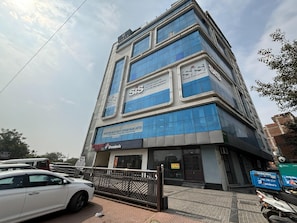 Monikerroksinen liikerakennus, jossa on kyltit, joissa lukee ’SIS Group Enterprises’ ja ’Rajasthan Rajya Vidyut Utpadan Nigam Limited’.