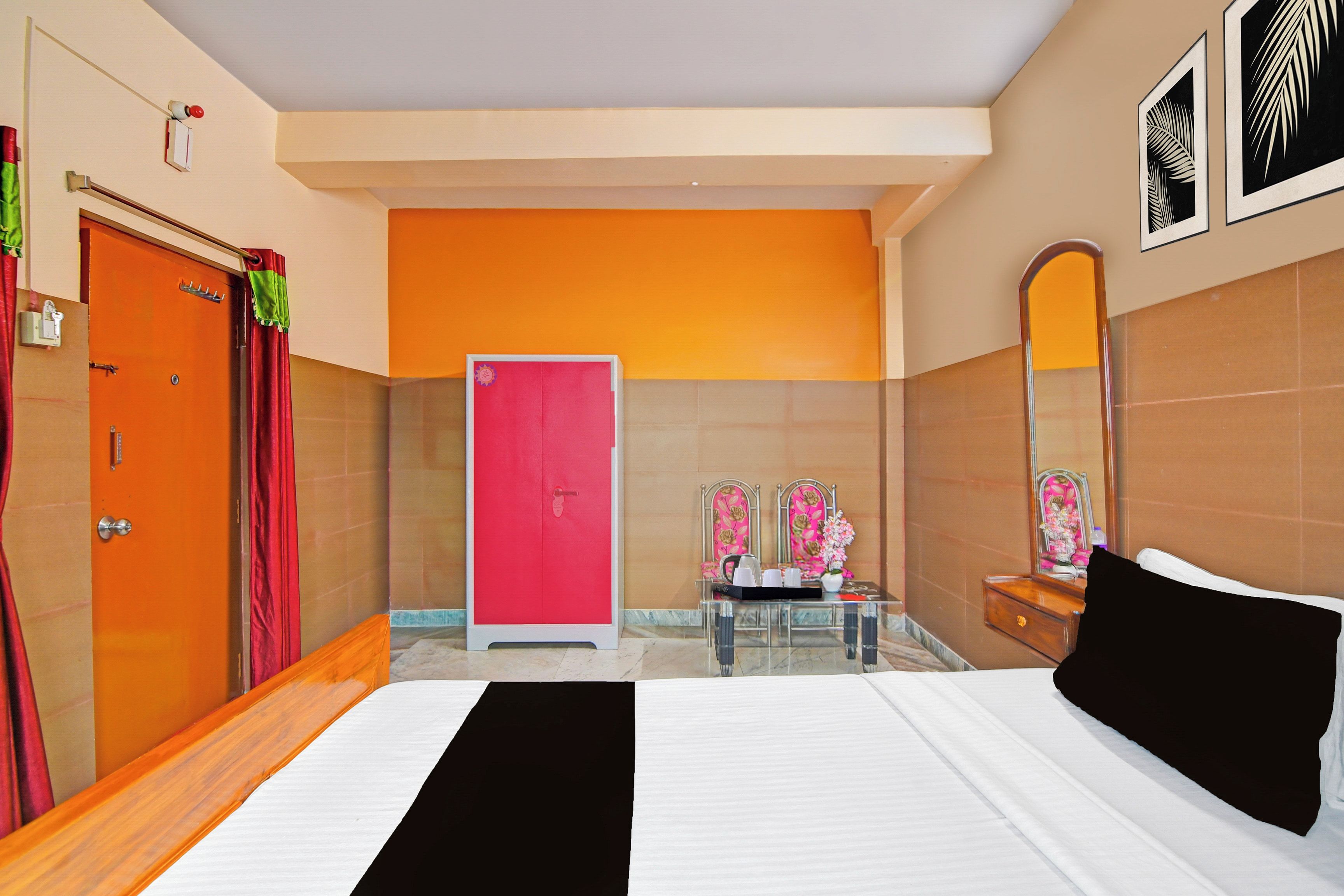 A hotel room with a bed, a bathroom with a mirror, and a door.