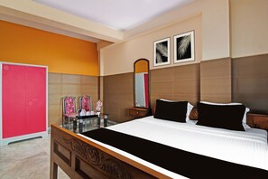 A hotel room with a bed, a vanity with a mirror, and a red wardrobe. - Super Hotel O Rishra Railway Station (Kolkata)