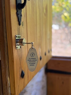 A wooden door with a metal latch and a keyhole.