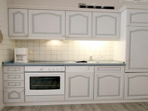A kitchen with white cabinetry, a built-in oven, a coffee maker, and a sink. - Holiday Apartment With 2 Bedrooms (Wyk auf Foehr)