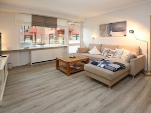 A modern living room with a sofa, a coffee table, and a painting on the wall. - Holiday Apartment With 2 Bedrooms (Wyk auf Foehr)