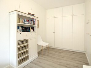 A room with a white bookshelf, a white chair, and a white wardrobe. - Holiday Apartment With 2 Bedrooms (Wyk auf Foehr)