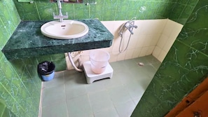 Kylpyhuone, jossa on pesuallas, suihku ja wc.