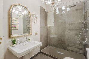 A bathroom with a large mirror, a sink, a shower, and a toilet. - Modern Apartment With Terrace, Lucca (Lucca)