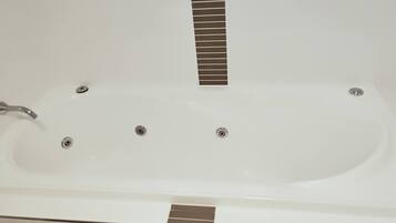 A white bathtub with a single faucet and three drain holes.