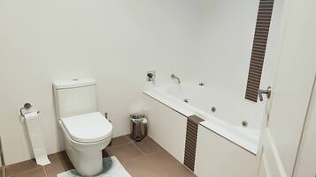 Un baño con inodoro, lavabo y espejo.