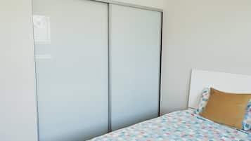 Ein Schlafzimmer mit einem Bett, einem Kopfteil, einem Kissen und einem Kleiderschrank.