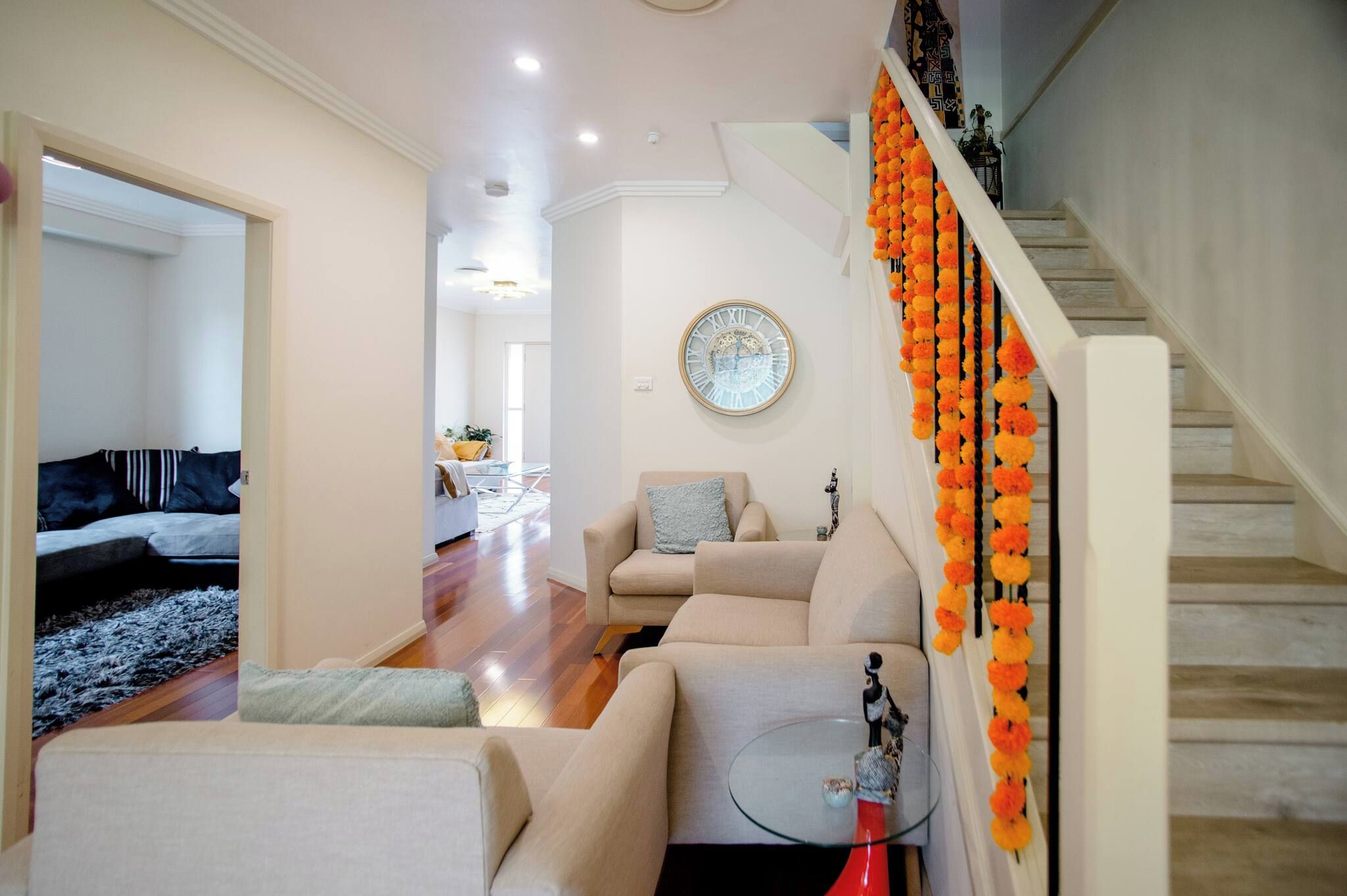 A living room with a sofa, a coffee table, and a decorative clock on the wall.