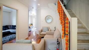 A living room with a sofa, a coffee table, and a decorative clock on the wall.
