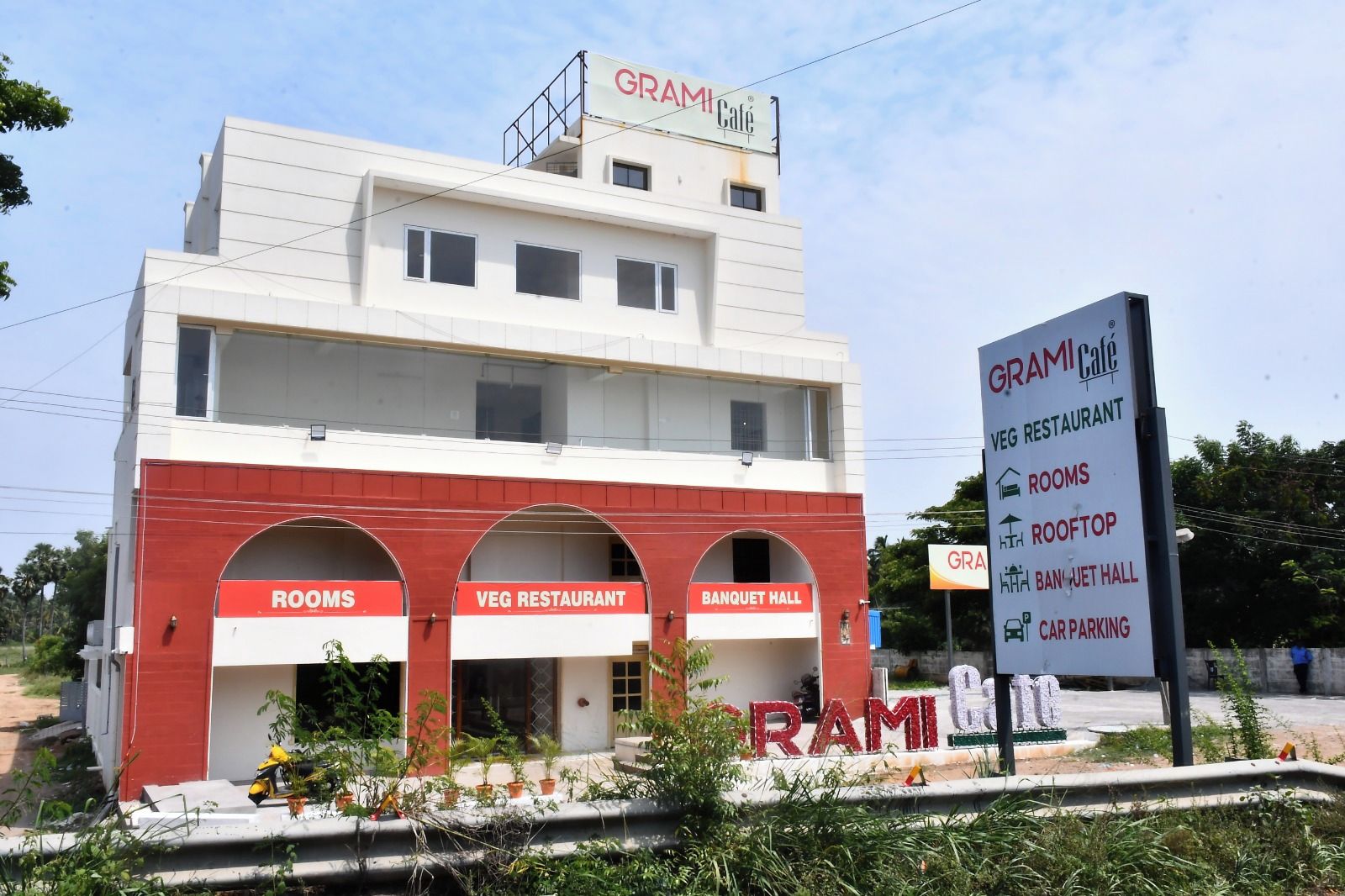 A building with a sign indicating it has rooms, a vegetarian restaurant, and a banquet hall.