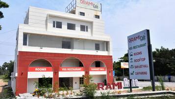 A building with a sign indicating it has rooms, a vegetarian restaurant, and a banquet hall.