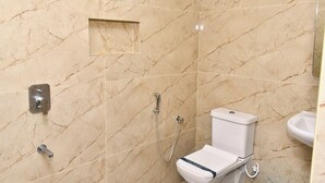 A bathroom with a toilet, a shower, and a sink. - Grami Cafe (Edayarpalayam)