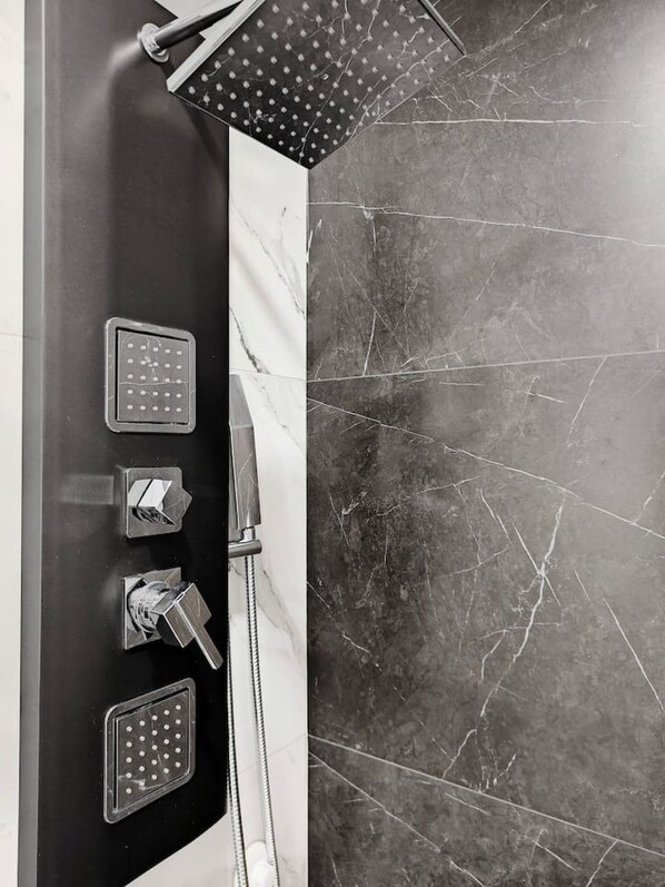 A shower with multiple heads and a control panel.