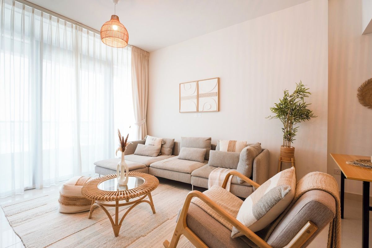 A modern living room with a sectional sofa, a round coffee table, and a hanging light fixture.