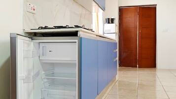 A kitchen with a built-in refrigerator, a stove, and blue cabinets.