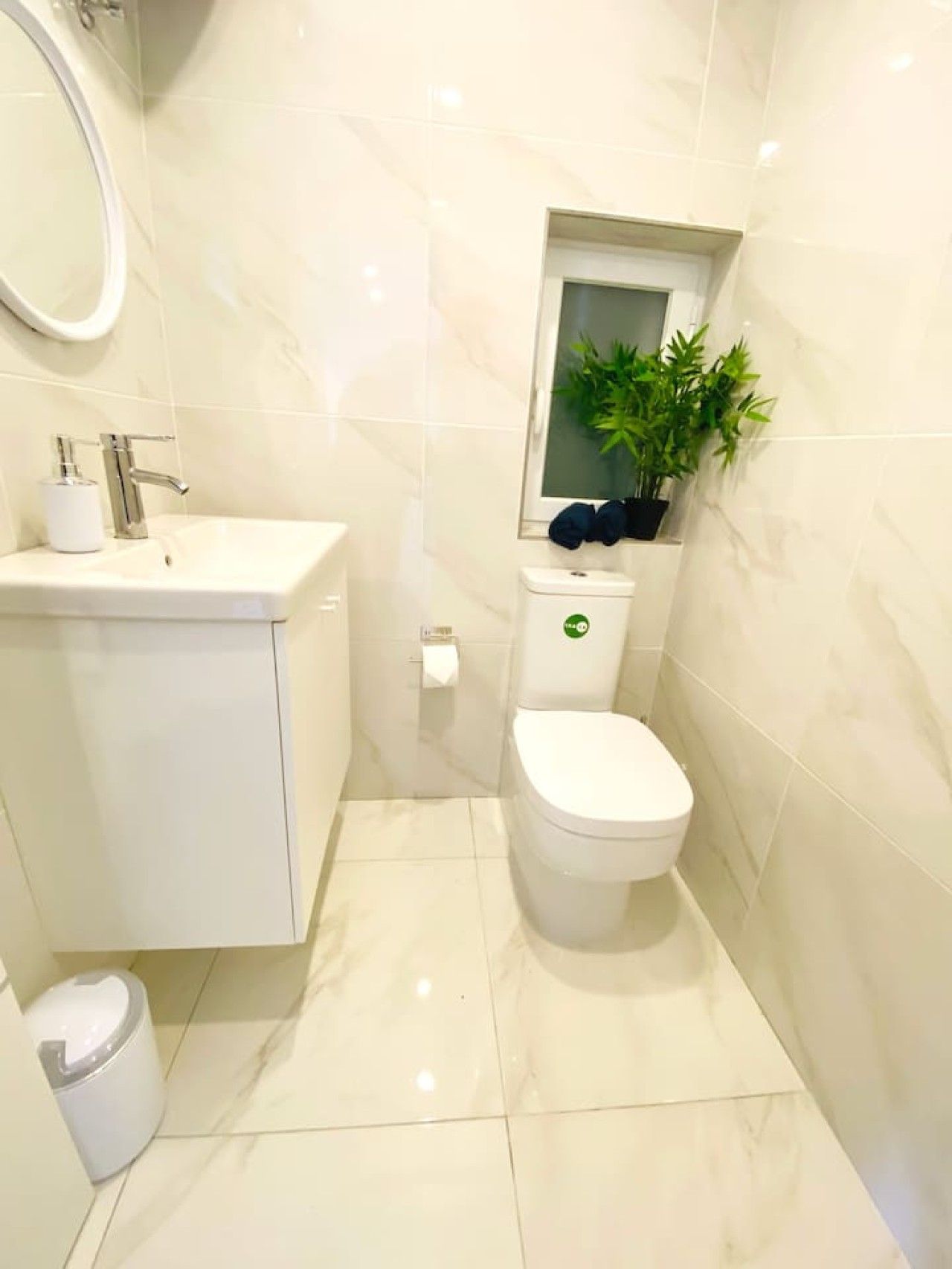 A modern bathroom with a white sink, toilet, and bidet.